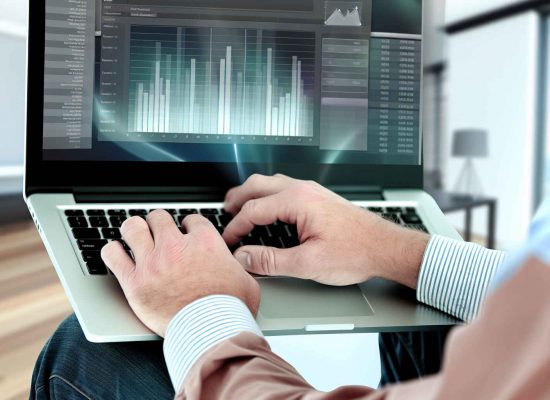 Empresário de microempresa brasileira usando software de contabilidade em laptop, gráficos financeiros visíveis na tela, ambiente moderno de escritório, estilo realista, horizontal 16:9